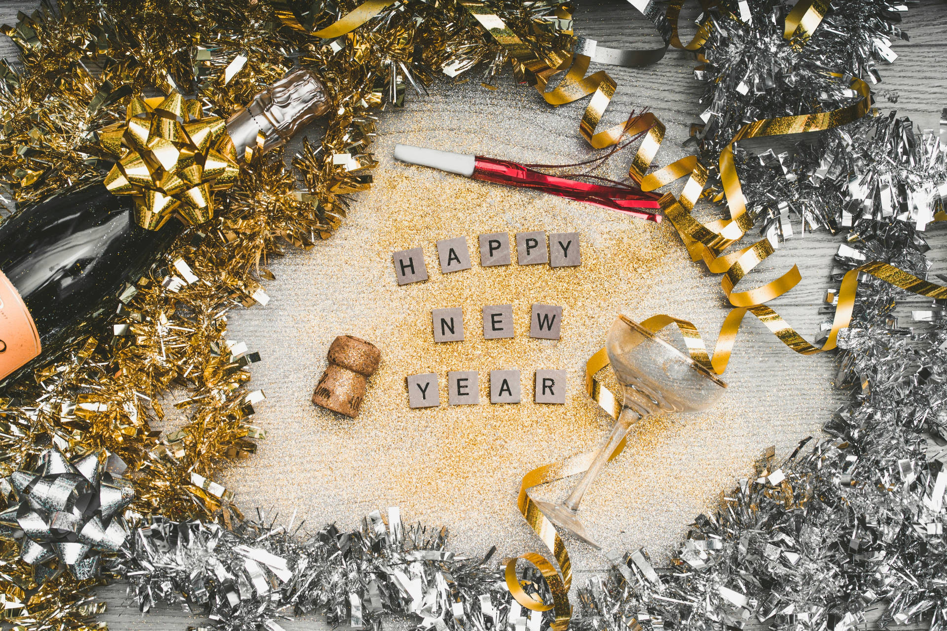大除夕慶祝，有香檳杯、閃粉和拼出happy new year的木塊。