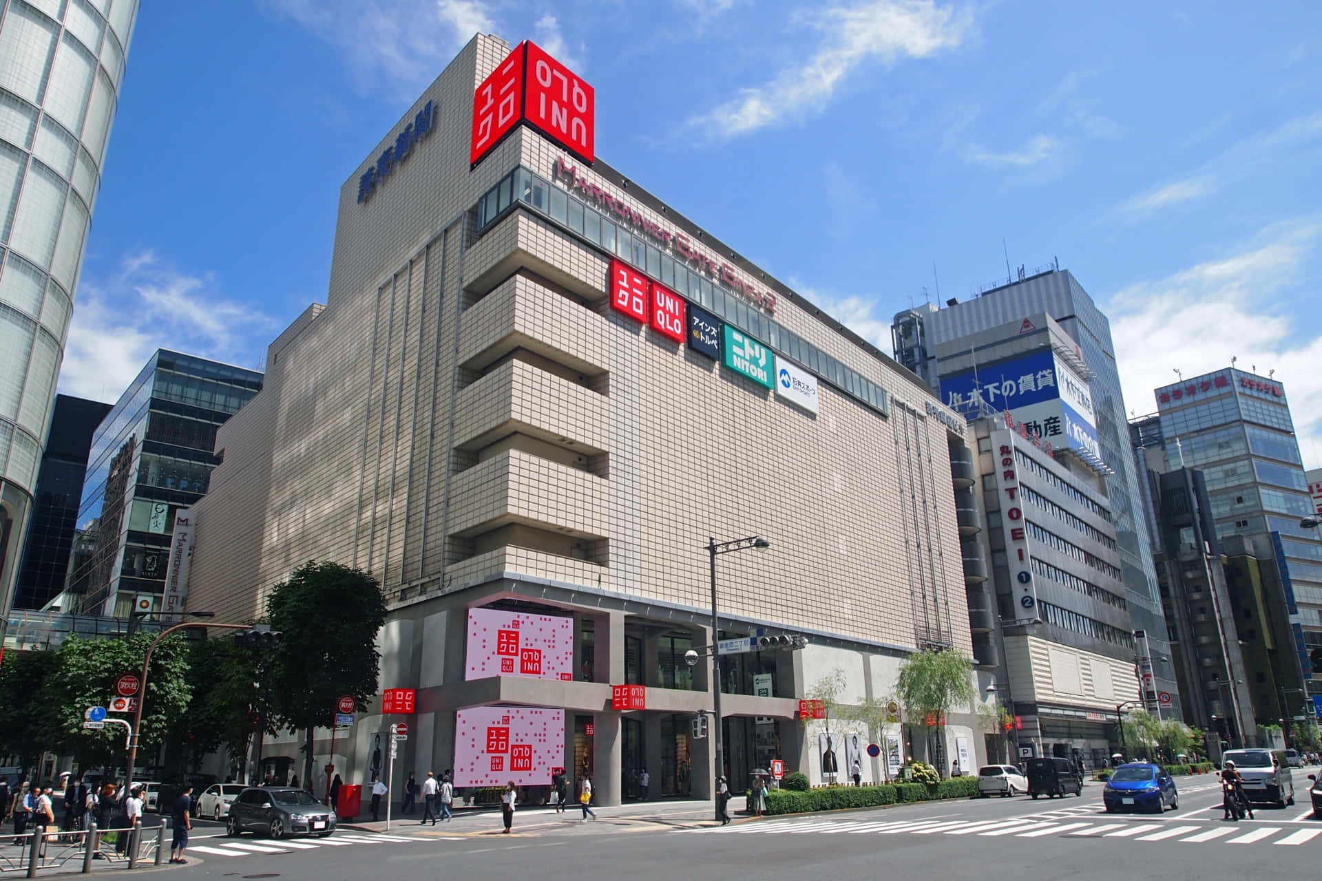 東京一座現代化的 Uniqlo 建築，在晴朗的日子裡有行人和汽車。