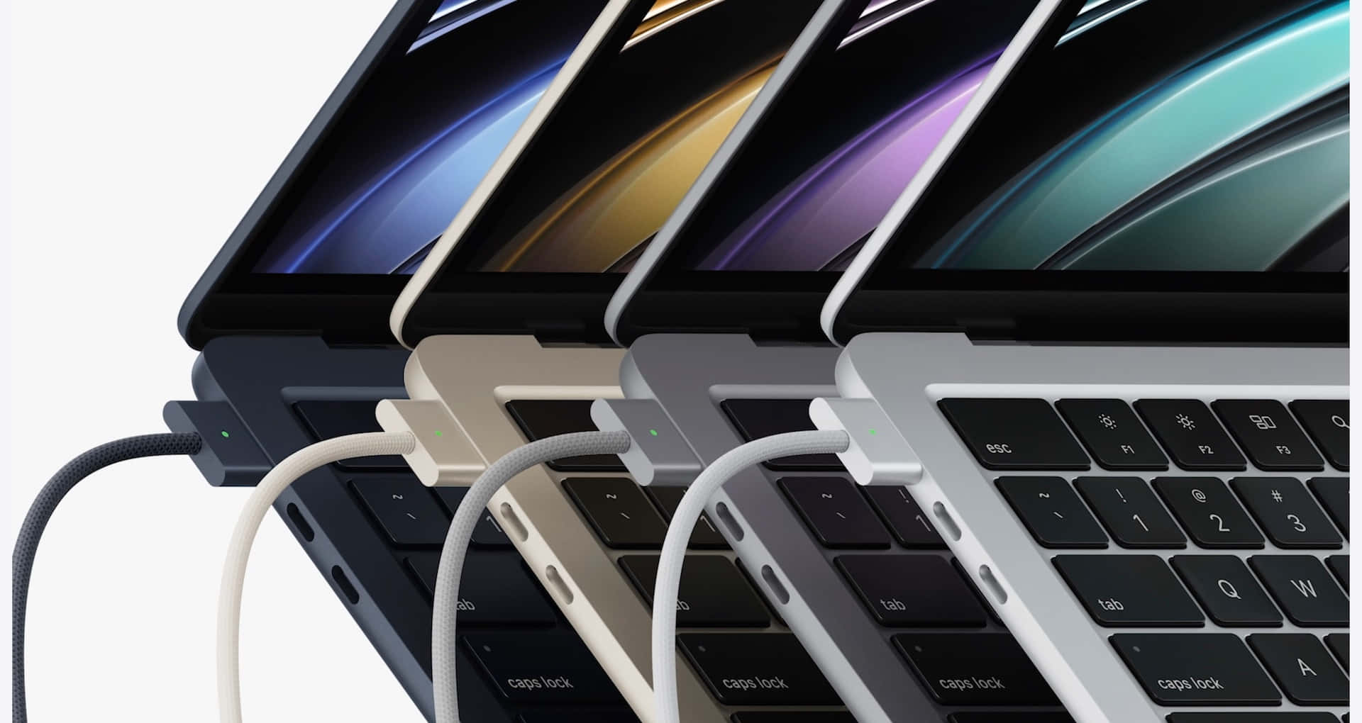 以全新Apple MacBook提升學習效率 壁紙 — 四部太空灰、銀色、金色和午夜黑色的 MacBook Pro 以對角線傾斜放置，帶有彩色漸變螢幕和已插入的充電線。