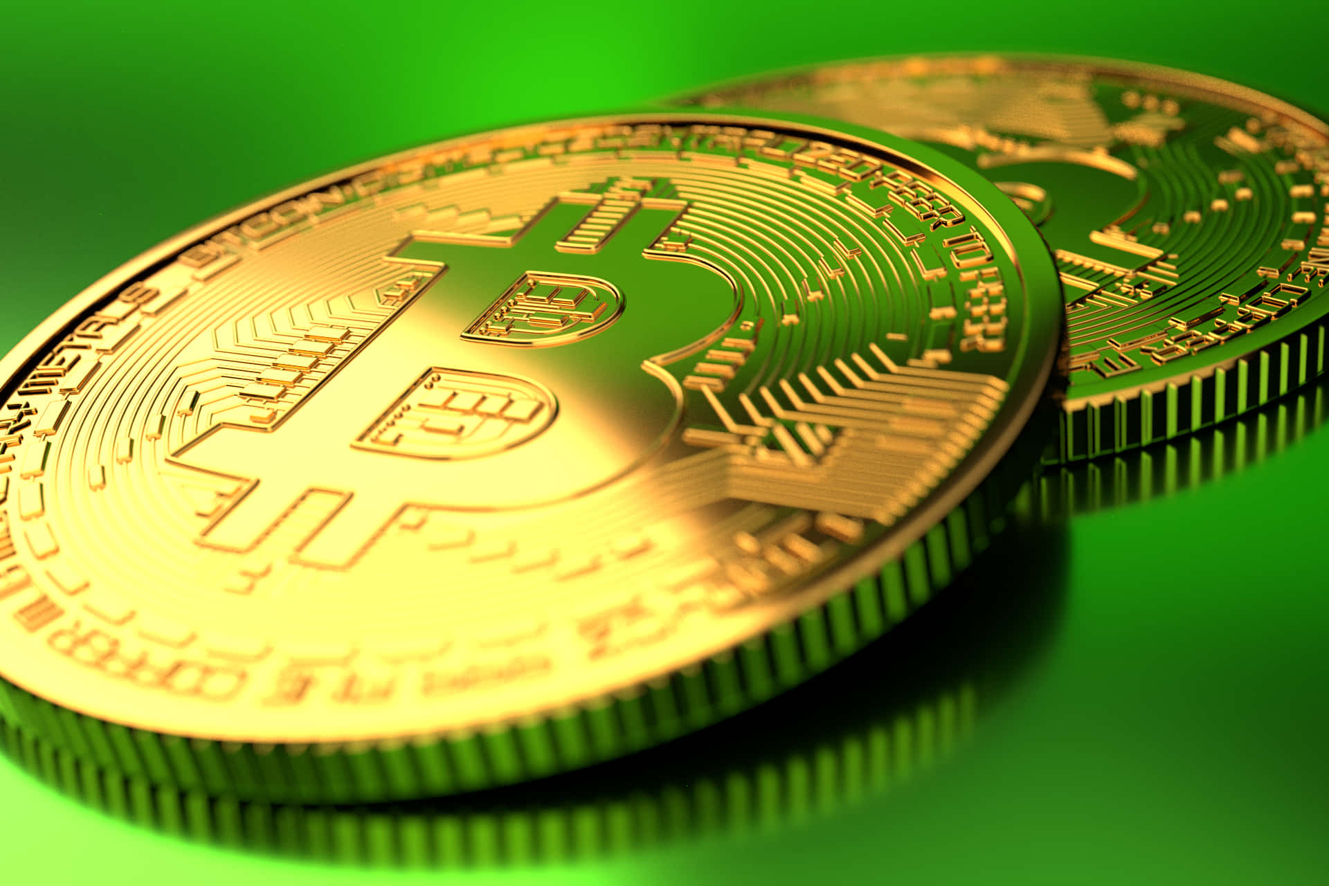 以全球首個去中心化加密貨幣——比特幣，掌握其力量 壁紙 — 兩枚閃閃發光的金色比特幣硬幣放在充滿活力的綠色表面上，帶有銳利的反射和詳細的電路雕刻。