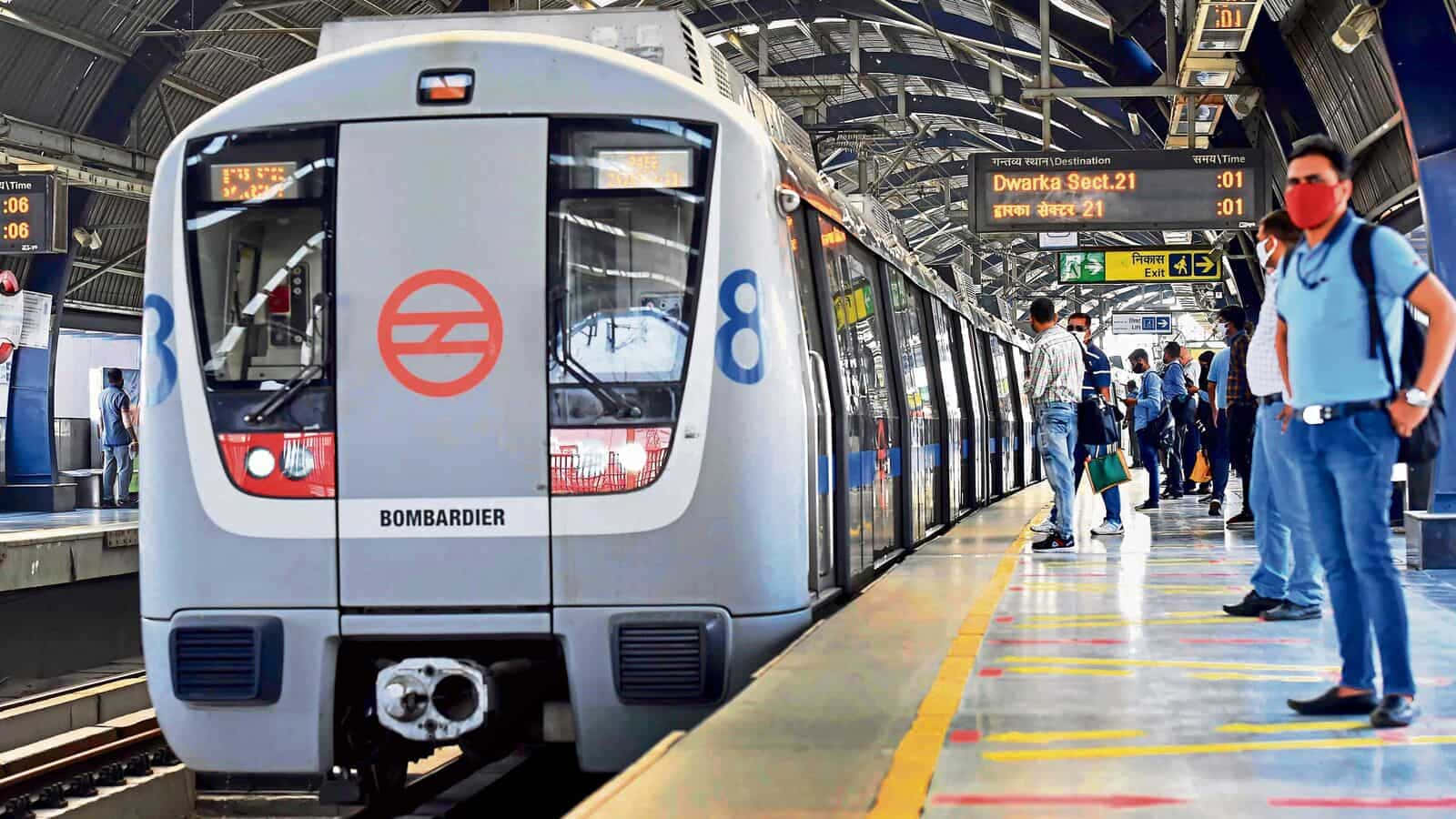 繁忙地下車站中銀色地鐵列車與等候的乘客。