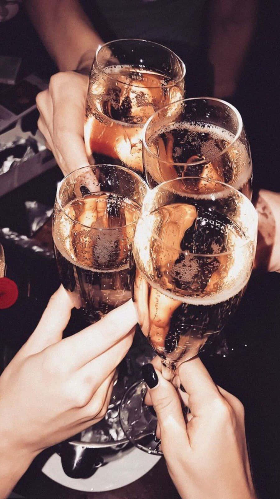 以冰涼啤酒慶祝生活！ 壁紙 — 四隻手碰杯香檳杯，裝滿冒泡的金色液體，進行慶祝乾杯。