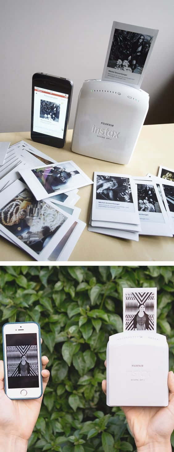 以印刷圖片點亮你的家或辦公室 壁紙 — 一部白色 Fujifilm Instax 打印機在木桌上及綠色樹葉背景前，於一部顯示相同圖像的智能手機旁邊輸出即時黑白照片。