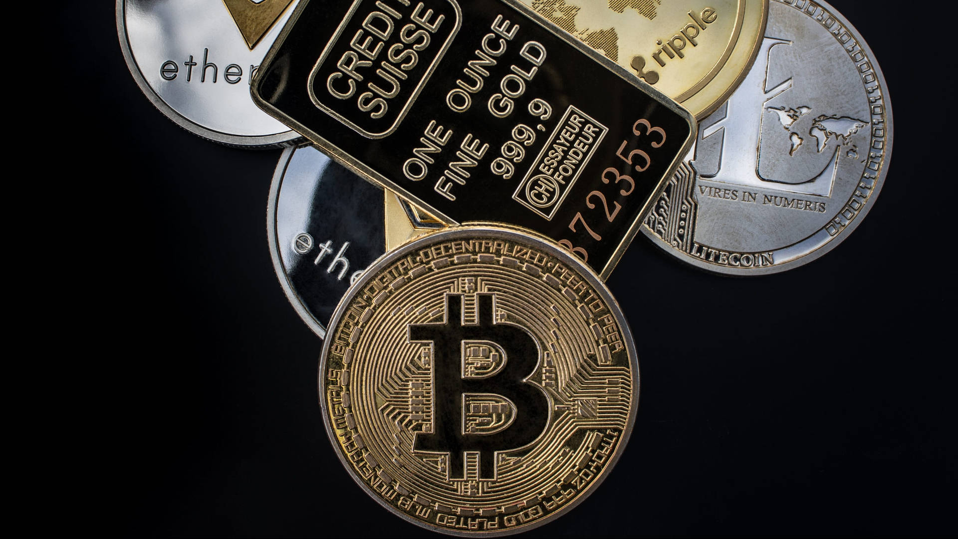 以太幣實體形式 壁紙 — 實體加密貨幣硬幣和金條在黑色背景上堆疊的特寫。