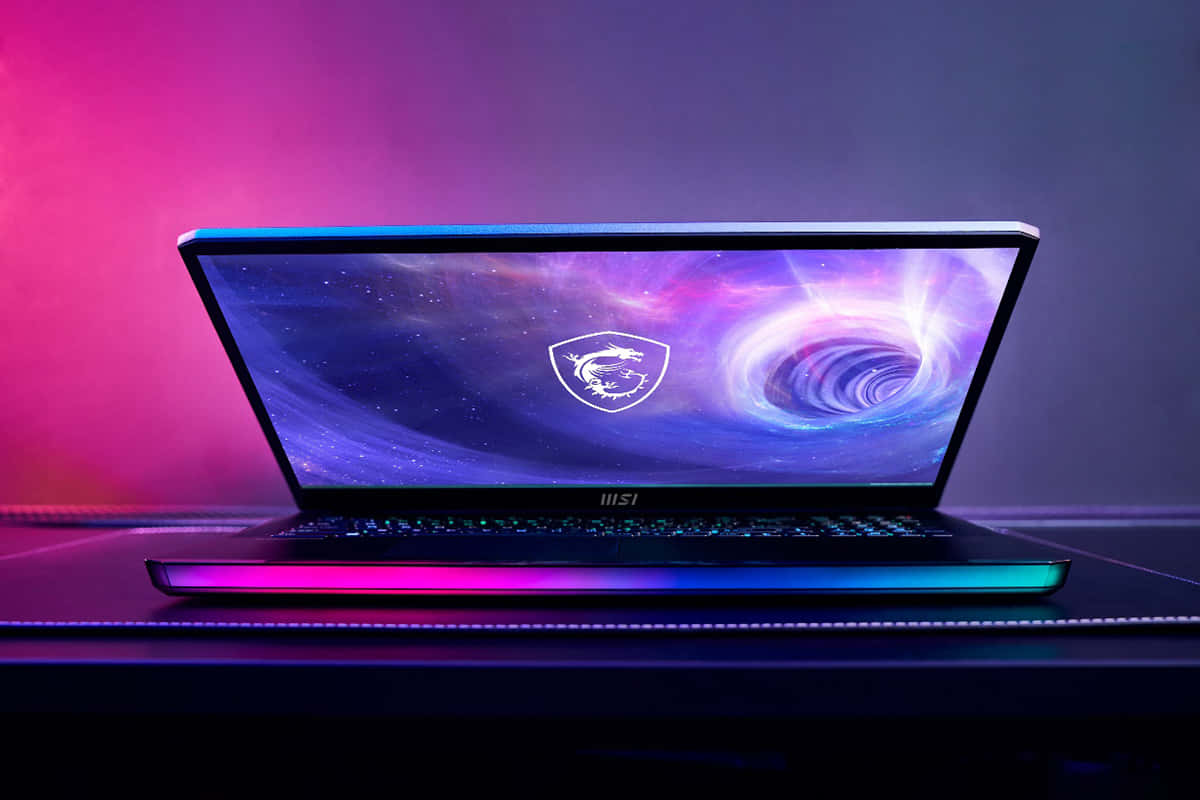 遊戲筆記型電腦，帶有宇宙壁紙和發光 RGB 鍵盤，在粉紅和紫色燈光下。