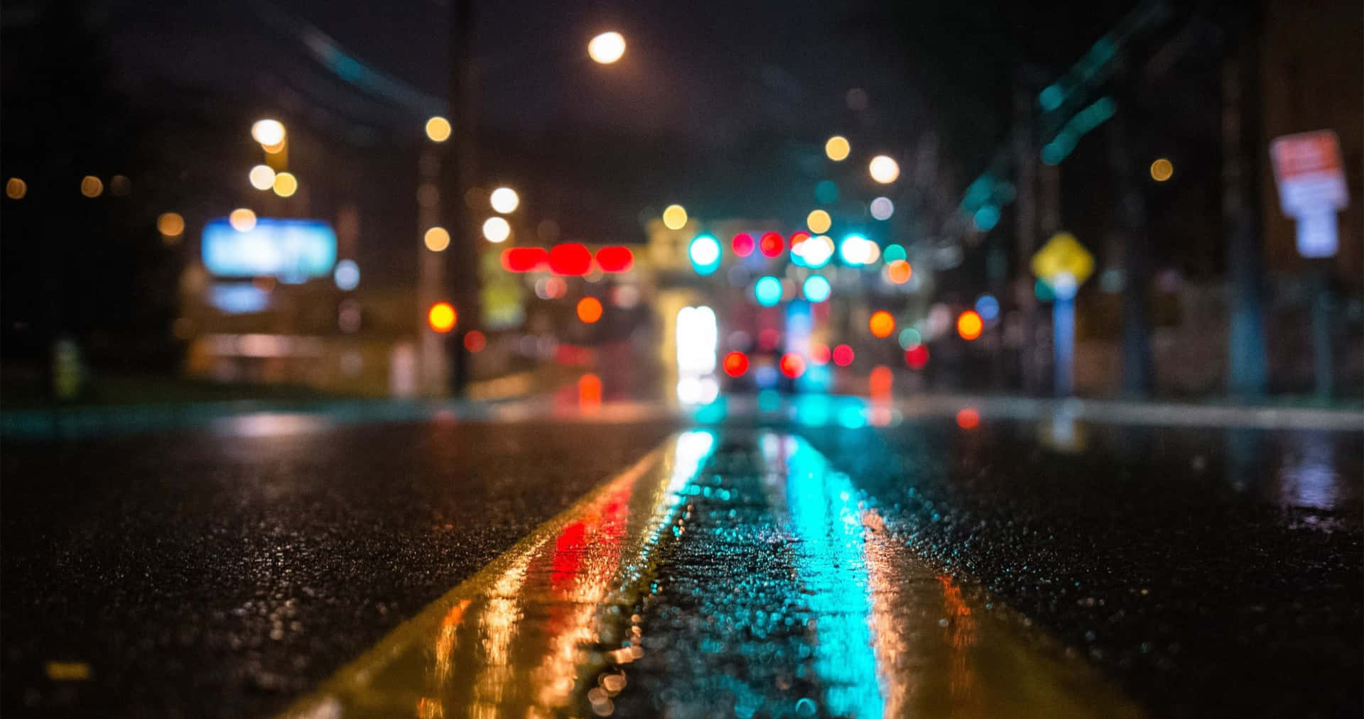 雨夜街道，模糊的燈光反射在濕漉漉的路面上。