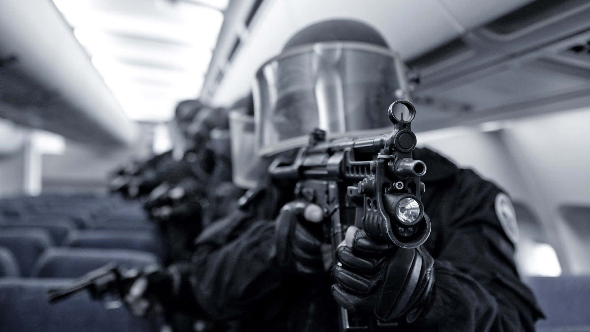 以戰術瞄準目標 壁紙 — 全副武裝的戰術警員在昏暗的飛機艙內瞄準步槍。