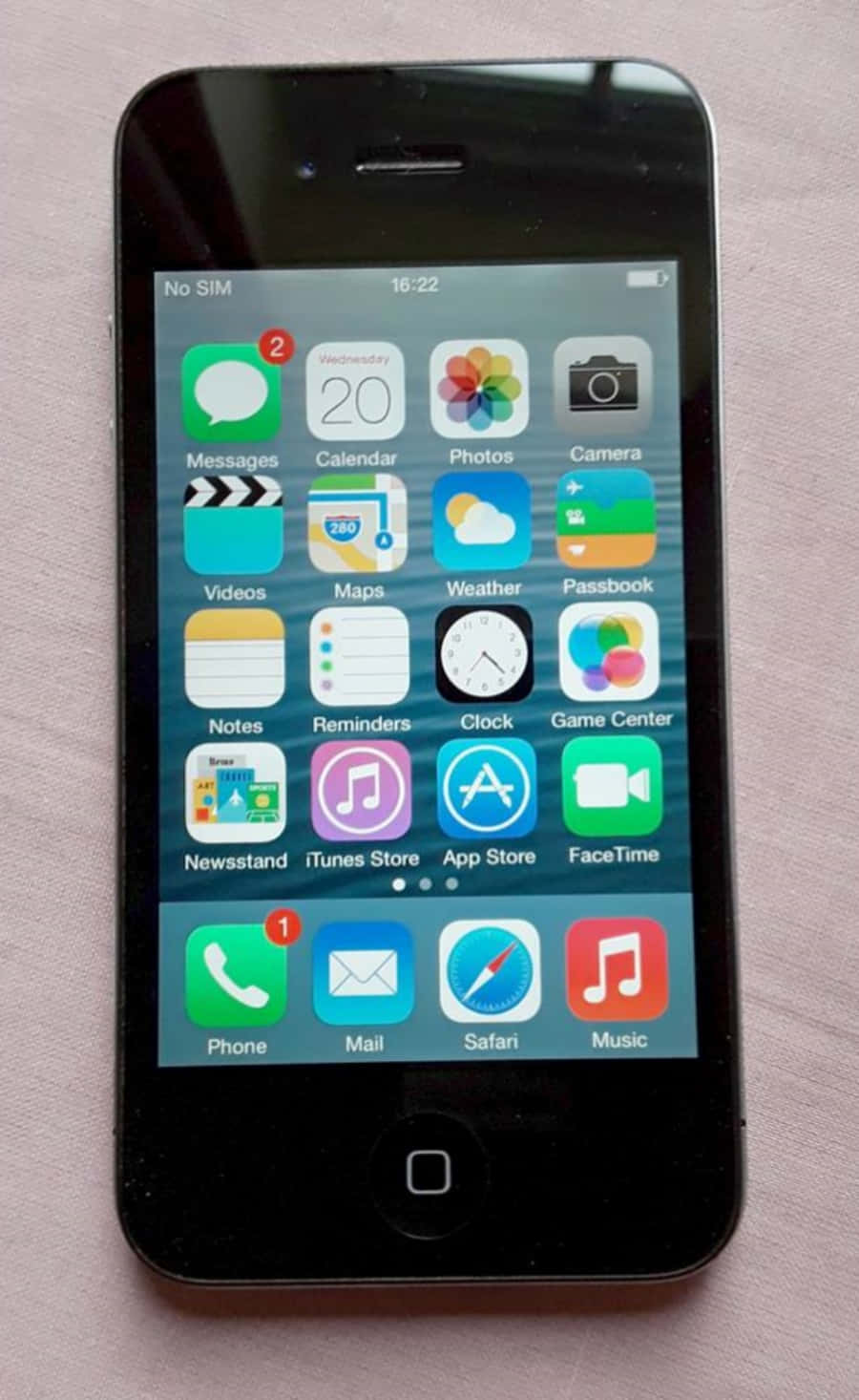 黑色 iPhone 4S 顯示 iOS 主畫面及應用程式圖示