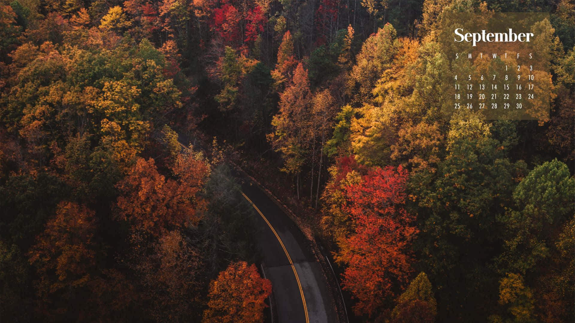 俯瞰一條彎曲的道路穿過色彩繽紛的秋樹，帶有九月日曆疊加。