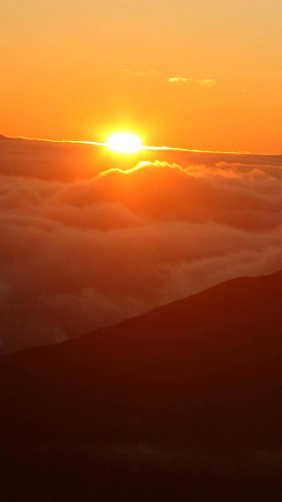 太陽在雲海上昇起，下方有山脈輪廓