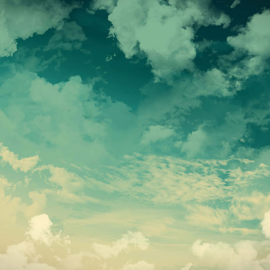 復古天空，青綠色和奶油色雲朵在柔和漸變中飄移。