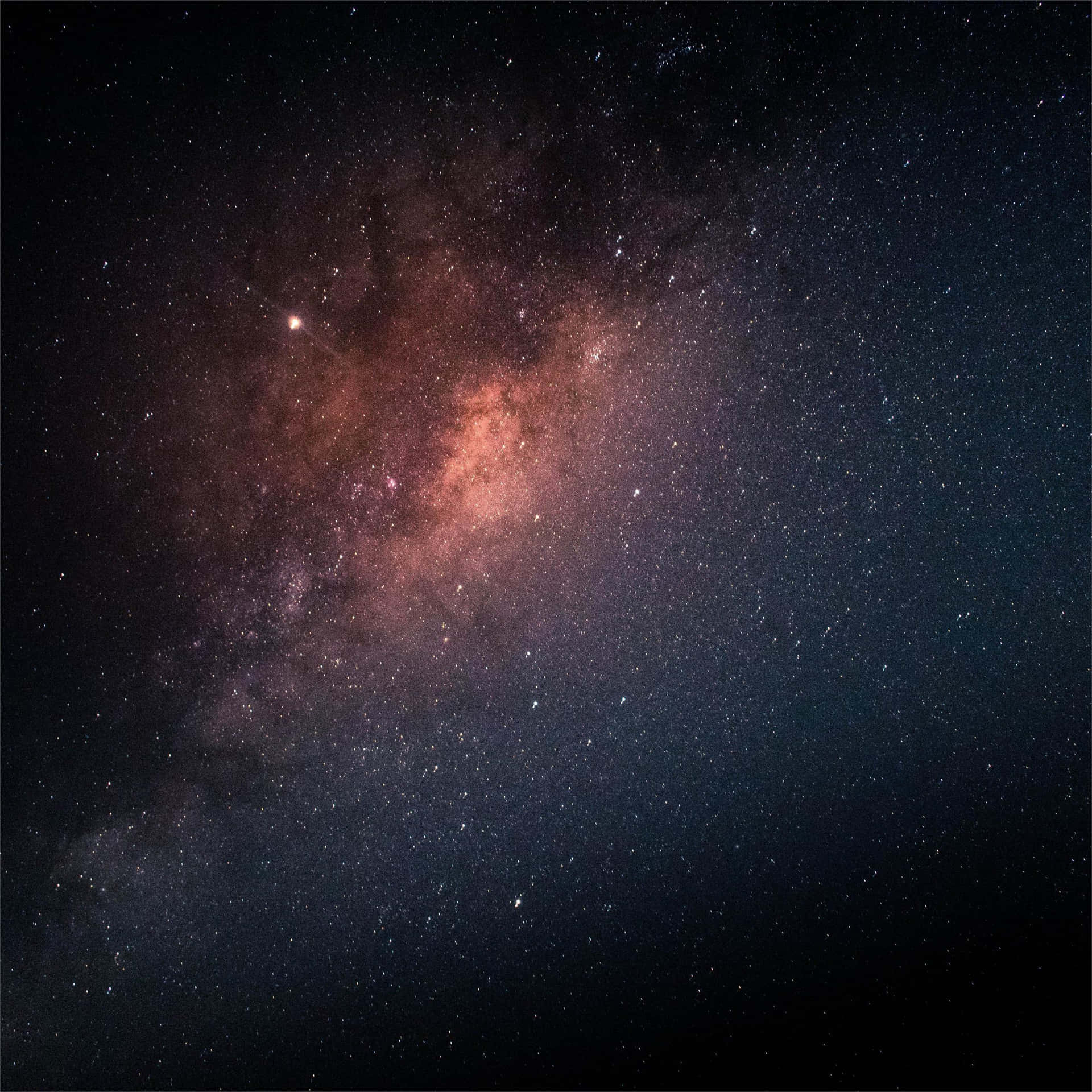 銀河系在夜空中閃耀著粉紅色和紫色的星雲，以及無數的星星。