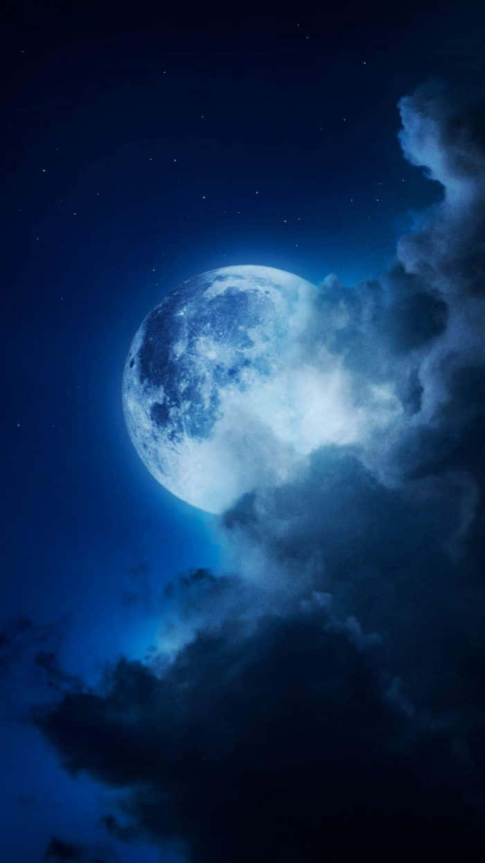 以月光 iPhone 捕捉滿月之美 壁紙 — 一輪明亮的滿月穿過旋轉的烏雲，在繁星點點的午夜天空中發光。