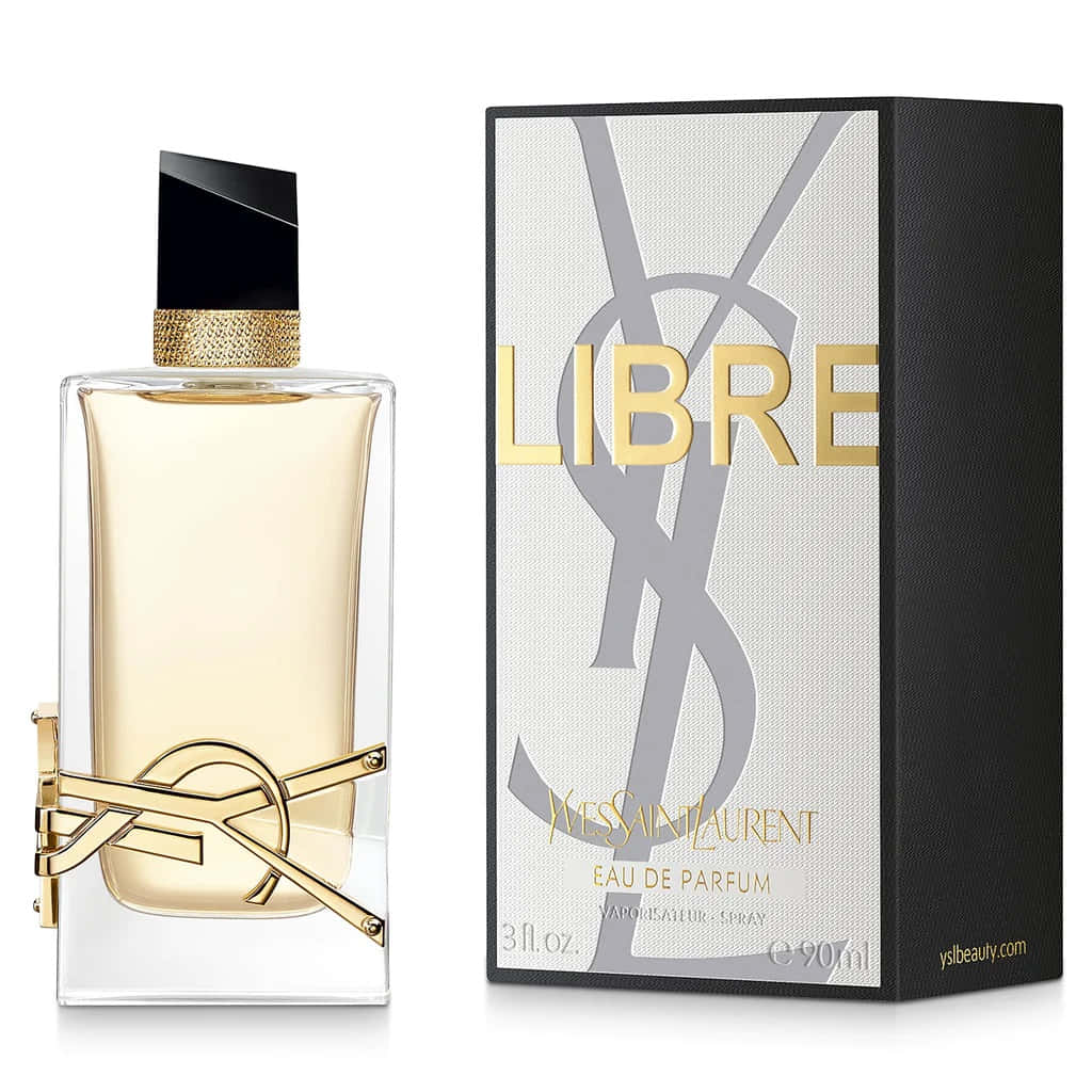 以柔粉背景增添奢華氣息，靈感來自YSL 壁紙 — 時尚的YSL Libre香水瓶，帶有金色裝飾和黑色瓶蓋，旁邊是帶有金色字樣的紋理盒子。