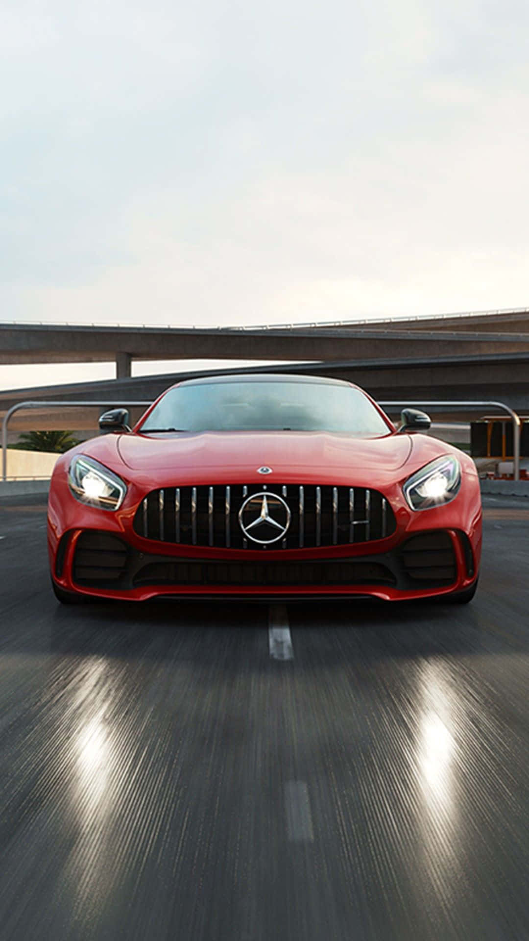 紅色 Mercedes-AMG GT 在天橋下的高速公路上飛馳。