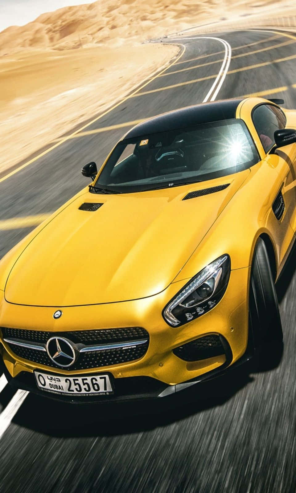 黃色 Mercedes 跑車在沙漠道路上飛馳，背景是沙丘。