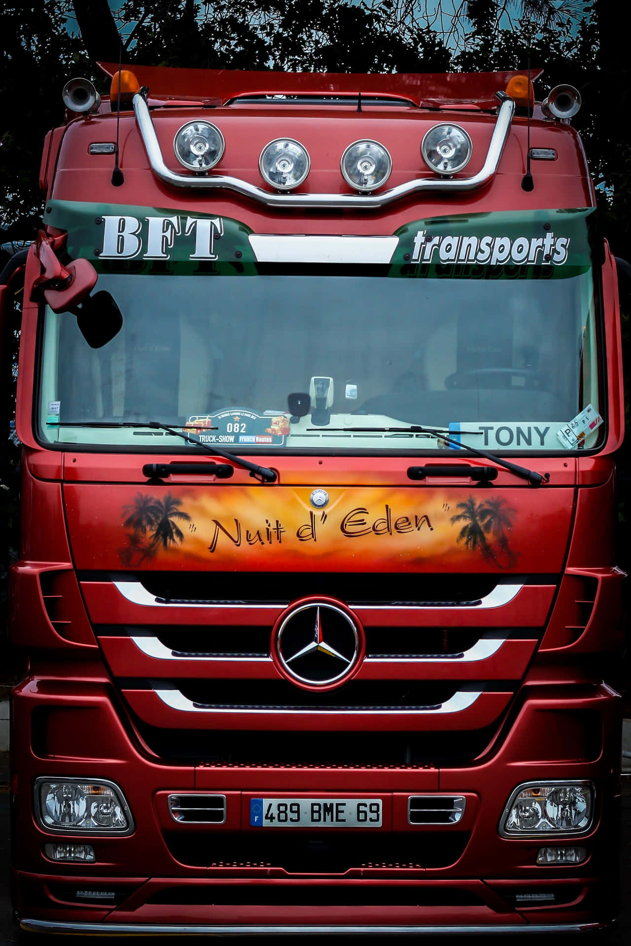 紅色Mercedes-Benz卡車，帶有「Nuit d'Eden」棕櫚樹設計和「BFT transports」標誌。