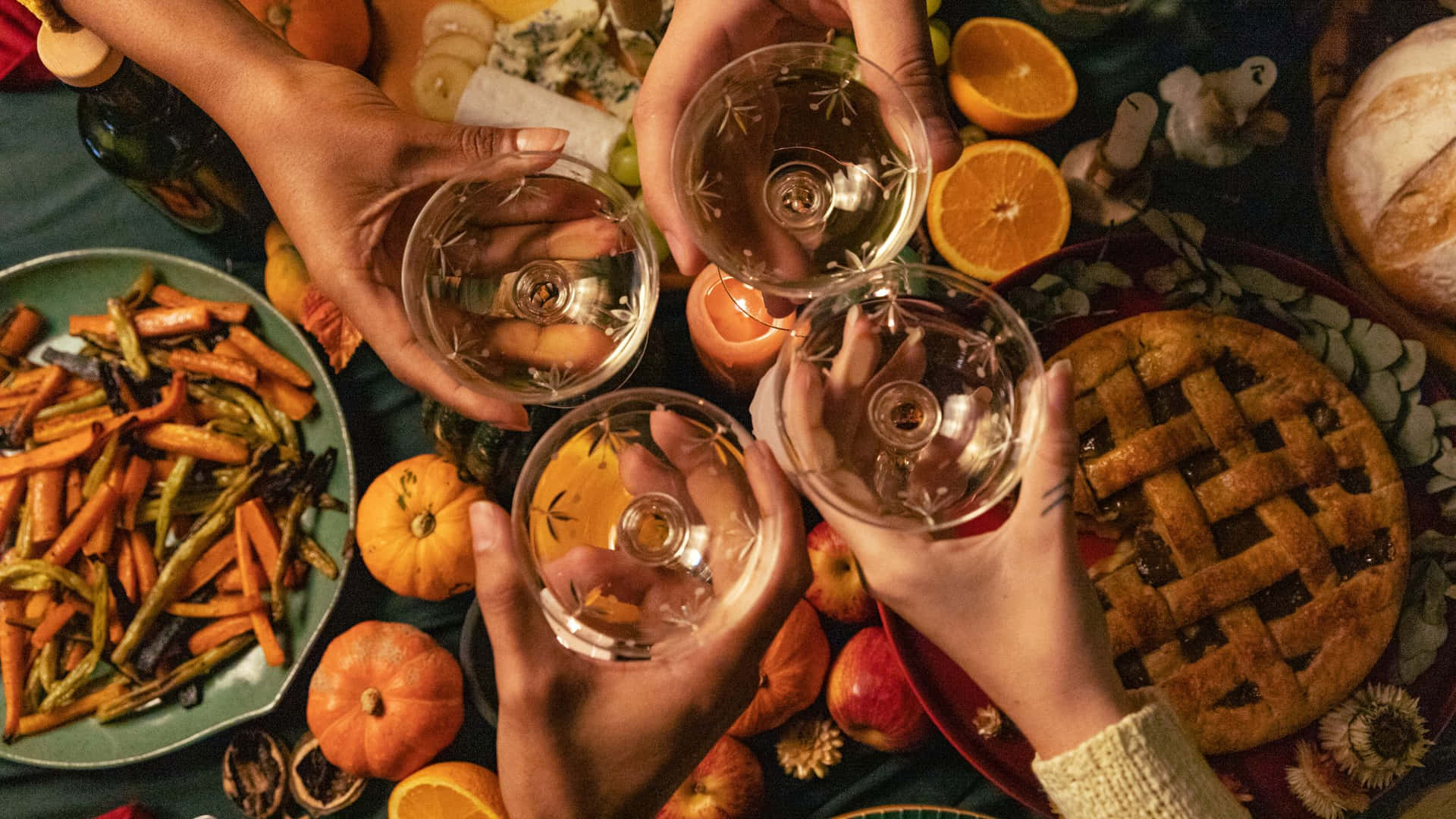 四隻手在秋季豐收盛宴上以酒杯祝酒。