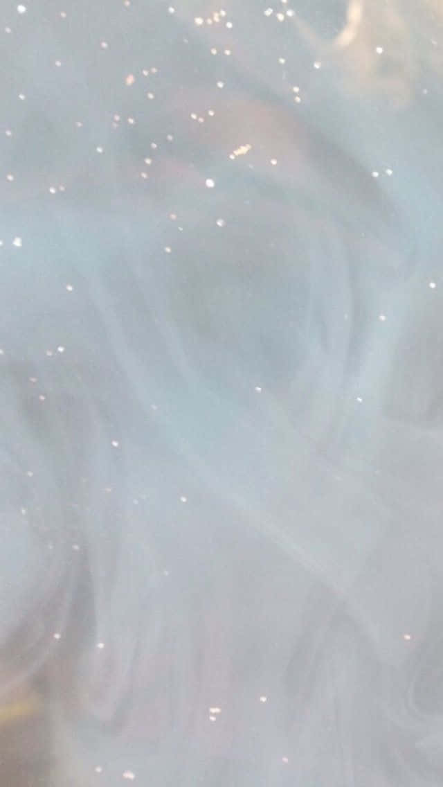 旋轉的藍色和白色煙霧，金色閃粉顆粒漂浮在夢幻的抽象場景中。