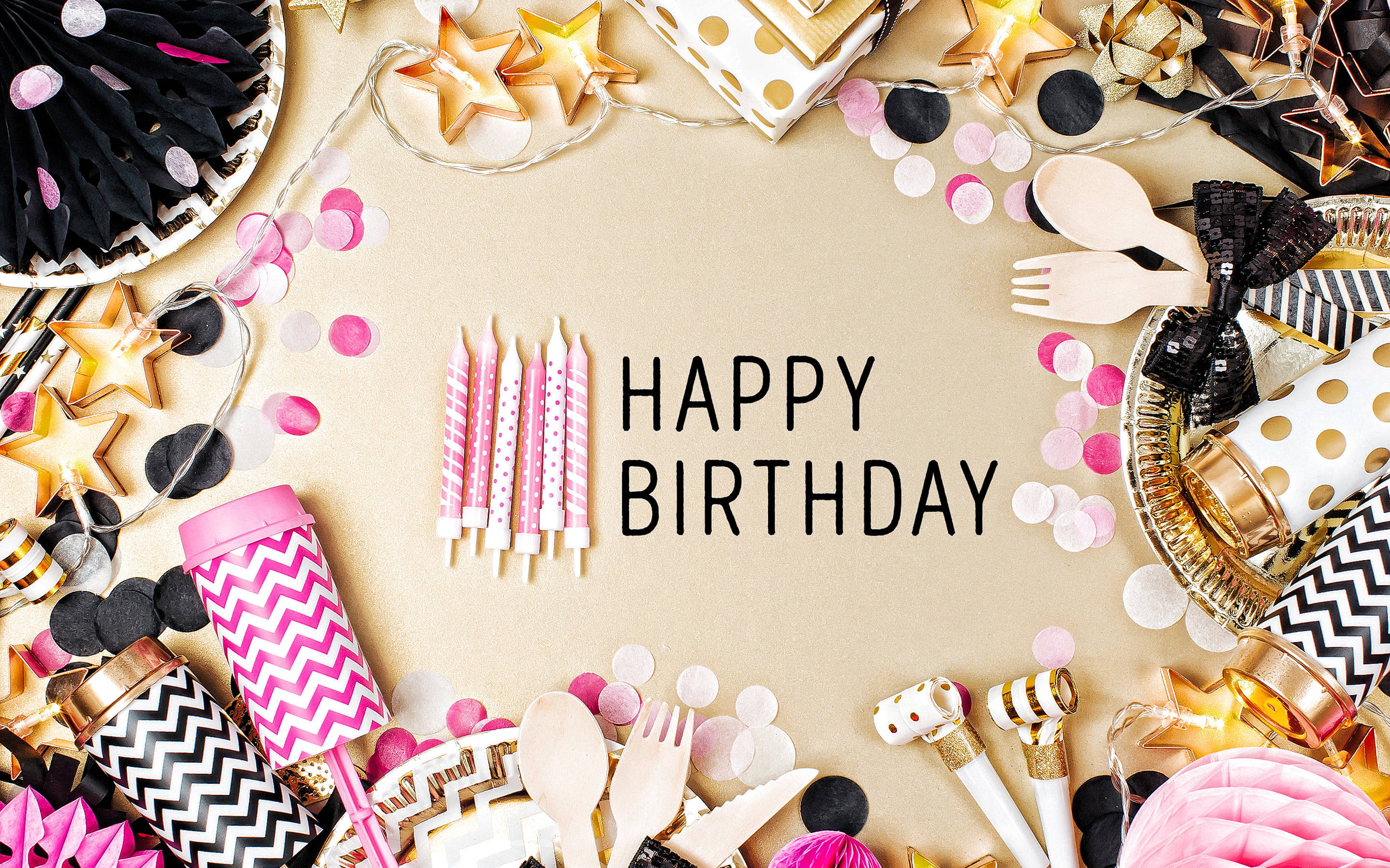 Birthday 桌布 壁紙 — 以粉紅、金色和黑色派對用品圍繞米色背景中央的「HAPPY BIRTHDAY」字樣，營造節日生日裝飾。