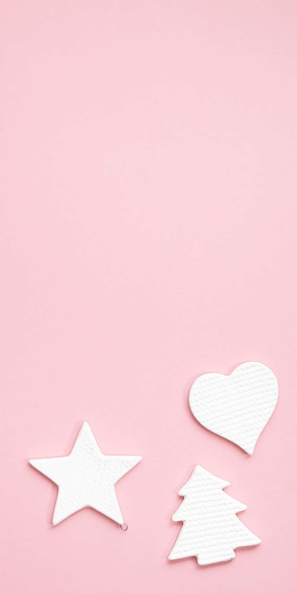 粉紅色背景上的白色星星、心形和樹木形狀