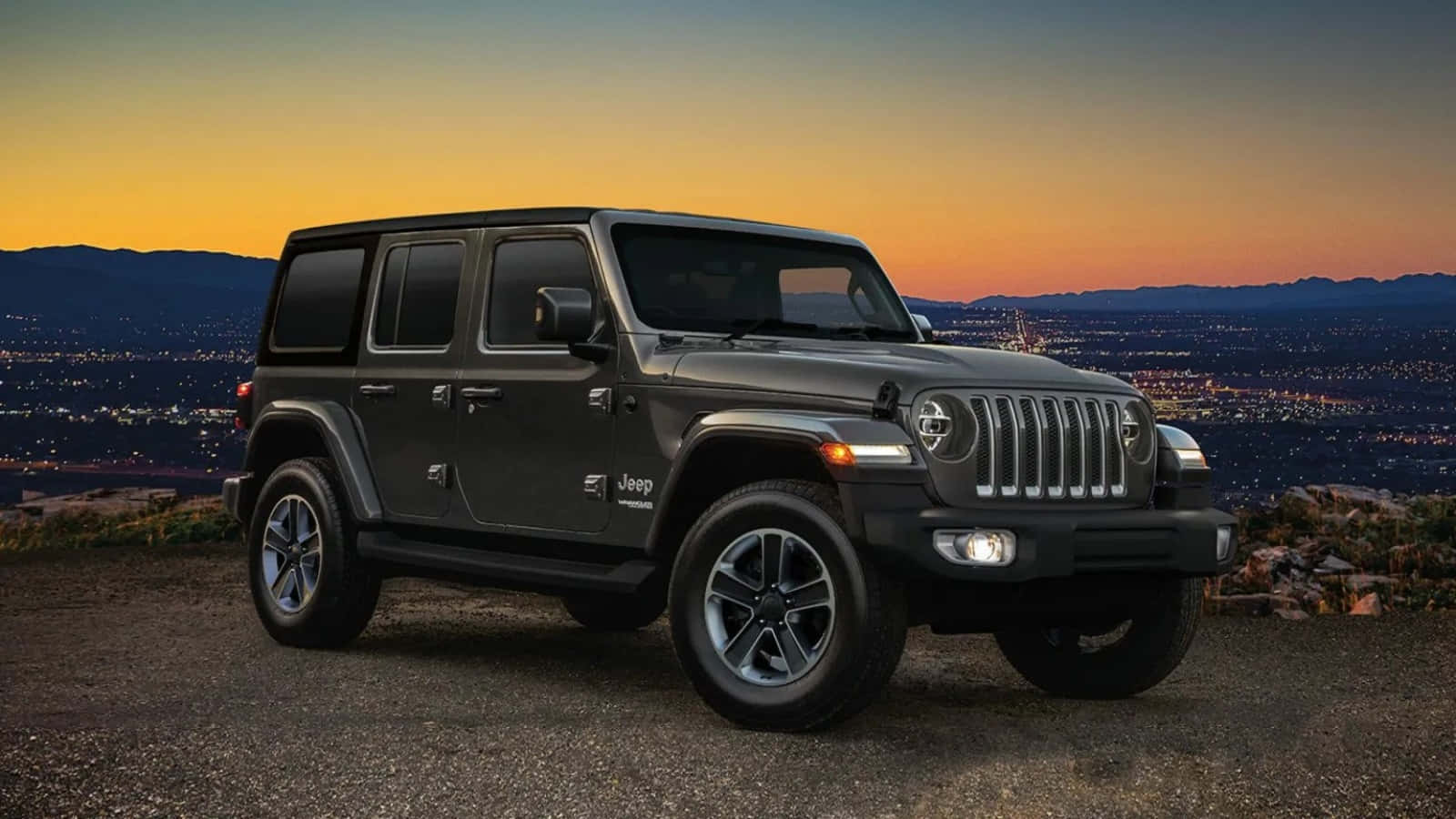 以經典Jeep Wrangler征服新小徑！ 壁紙 — 一架啞光黑色Jeep Wrangler停泊喺山頂，俯瞰夕陽下嘅廣闊城市，天空呈現溫暖嘅橙色同紫色。