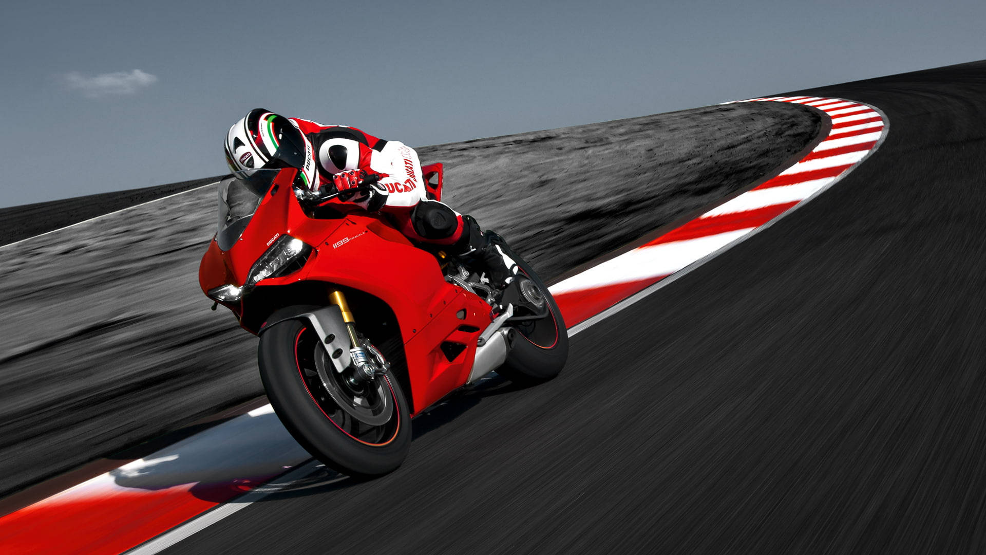 紅色Ducati電單車在彎曲賽道上飛馳，車手傾斜入彎。