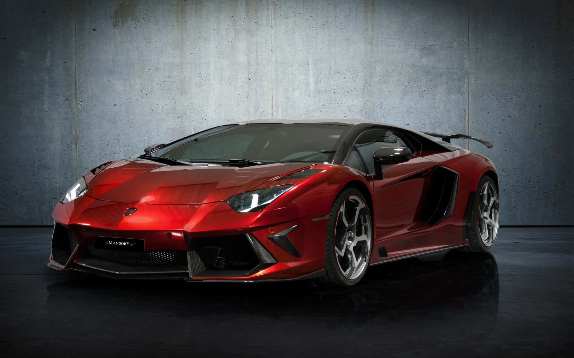 攝影棚中混凝土背景的紅色Mansory Lamborghini Aventador。