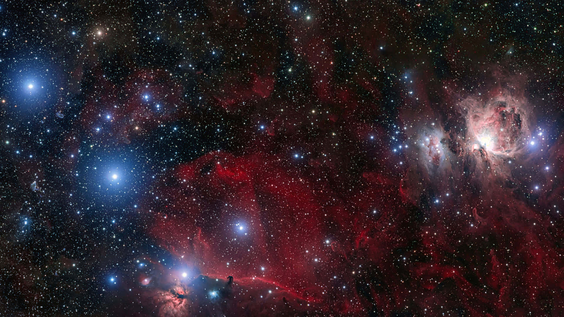 一個宇宙場景，有發光的紅色和藍色星雲以及無數星星。