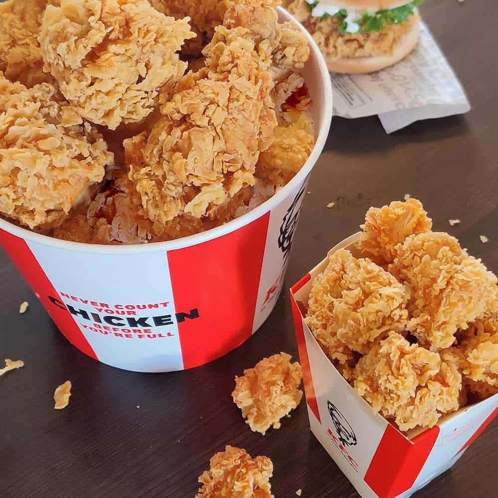 木桌上KFC桶中的酥脆炸雞。