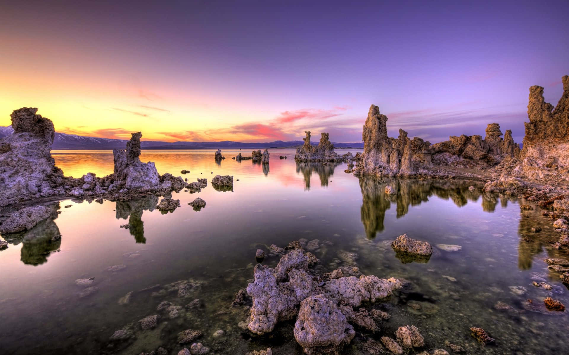 以色列古蹟俯瞰壯麗日落 壁紙 — Mono Lake 上壯觀的日出，超現實的凝灰岩塔在平靜的水面上倒映，天空呈現漸變的紫色和橙色。