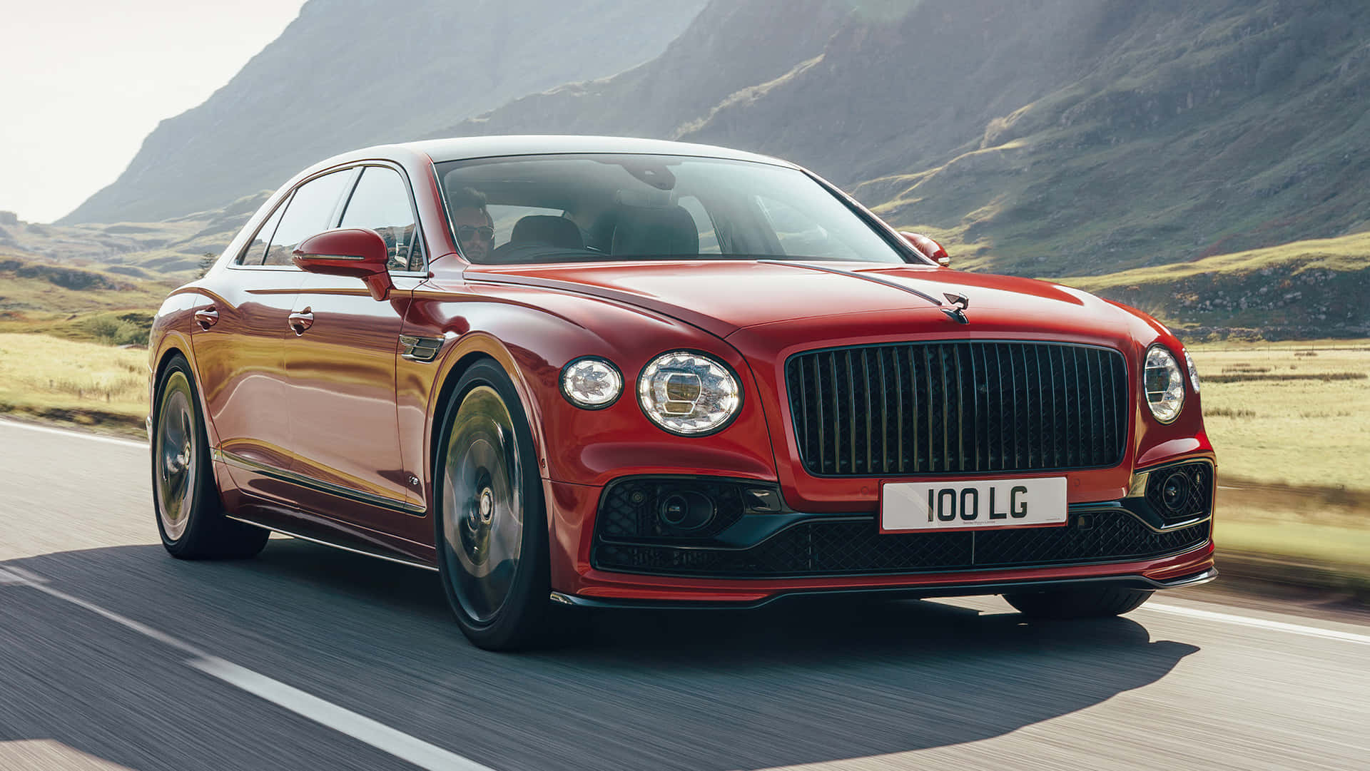 紅色賓利 Flying Spur 在日落時分於山路疾馳。