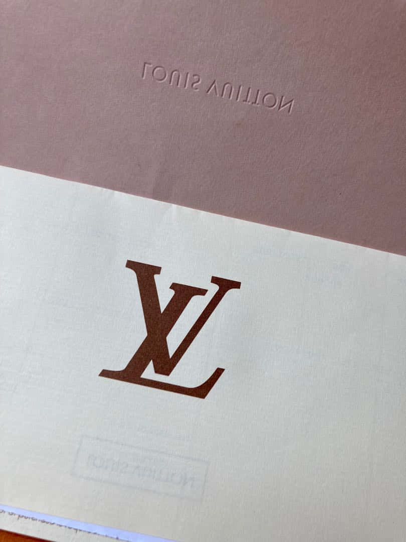 路易威登標誌在帶有紋理的米色和紫紅色紙張上，帶有壓印品牌。