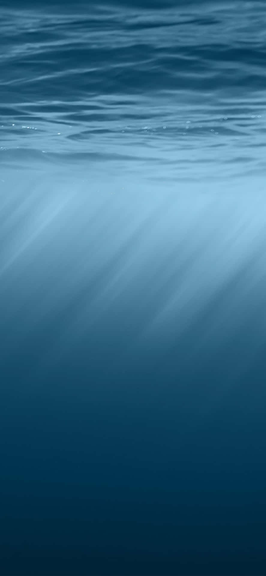 陽光穿過海面照射到深藍色海水中。