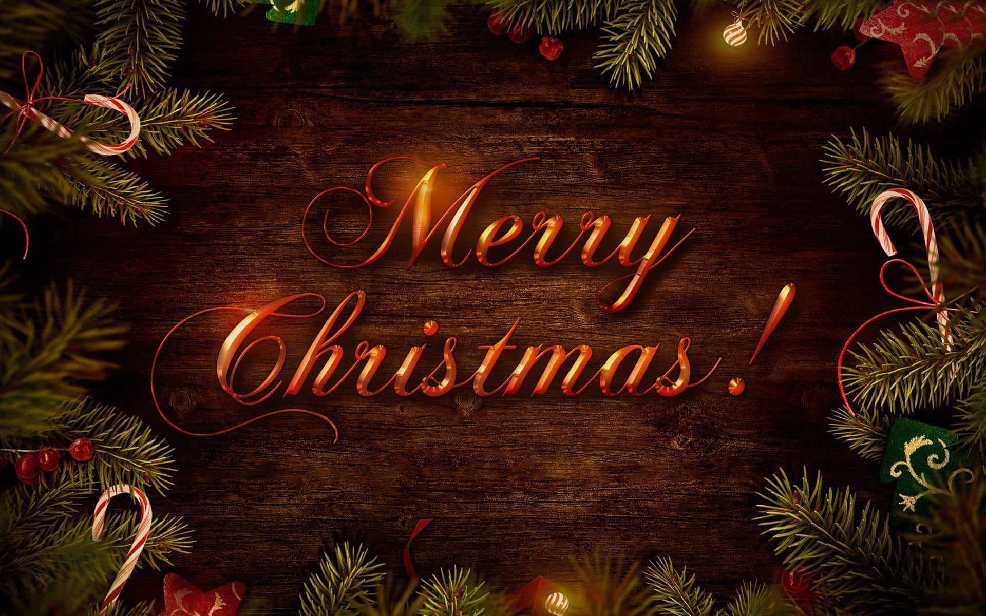 以這款節慶桌面背景慶祝節日！ 壁紙 — 金色嘅「Merry Christmas」字體喺由松樹枝、拐杖糖同節日裝飾框住嘅質樸木質背景上溫暖咁發光。