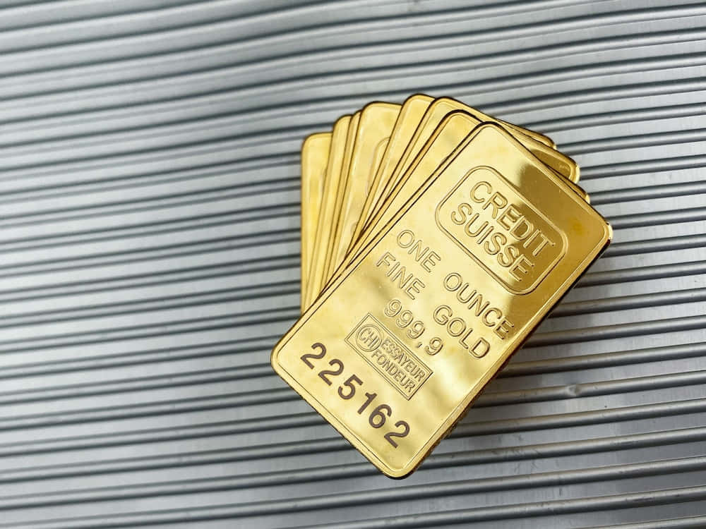 一堆 Credit Suisse 金條放在波紋金屬背景上。