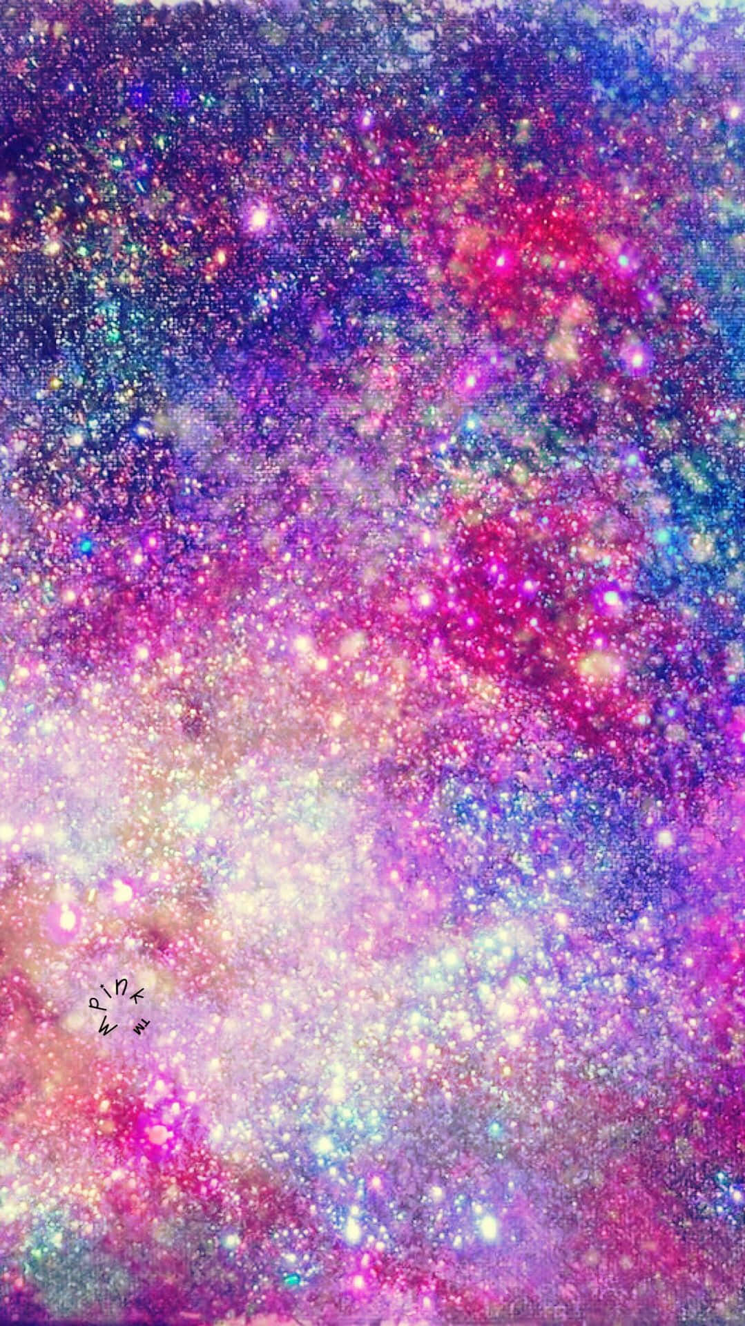 以閃爍背景照亮您的設備 壁紙 — 一個充滿活力的宇宙星雲，在夢幻般的銀河背景下，旋轉著閃閃發光的粉紅色、紫色和藍色星星。