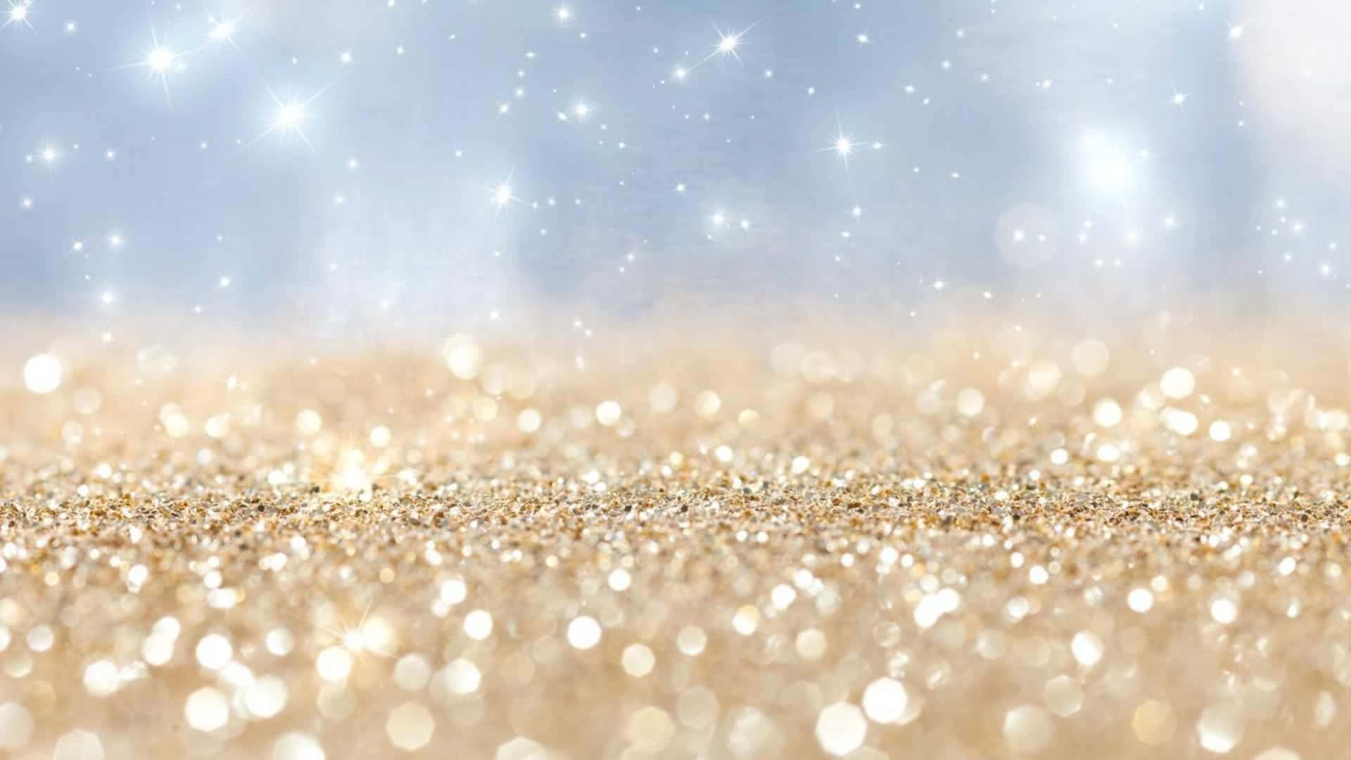 以閃耀星光背景為生活注入歡樂與光亮 壁紙 — 金色閃閃發光的沙子在柔和的藍天下閃爍，帶有閃爍的星形散景燈光。