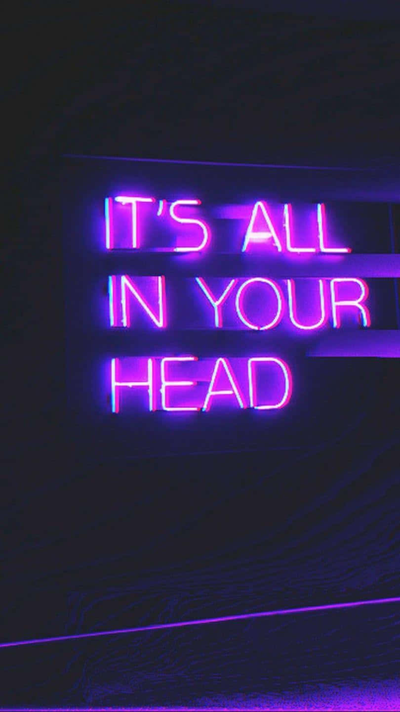 深色牆上寫著「IT'S ALL IN YOUR HEAD」的紫色霓虹燈牌。