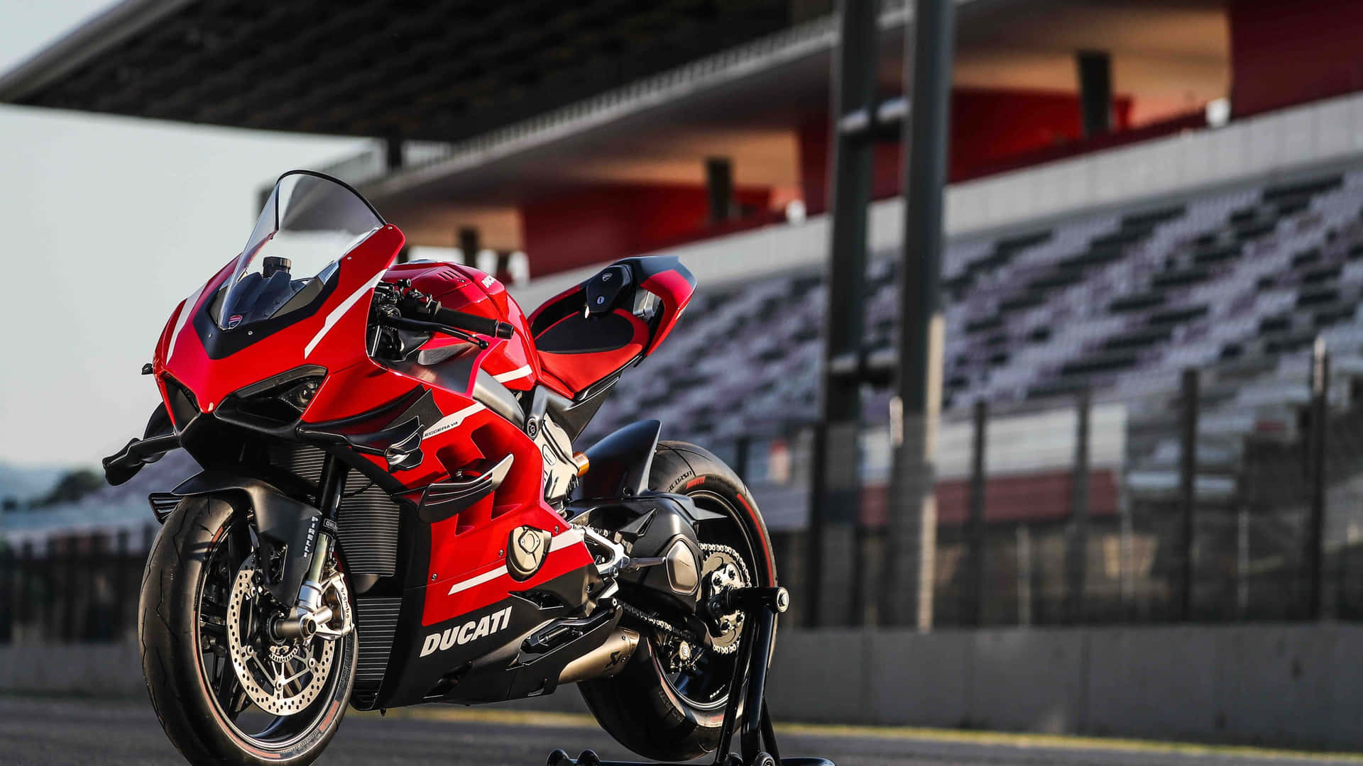 紅色Ducati電單車在賽道上，背景是空看台。