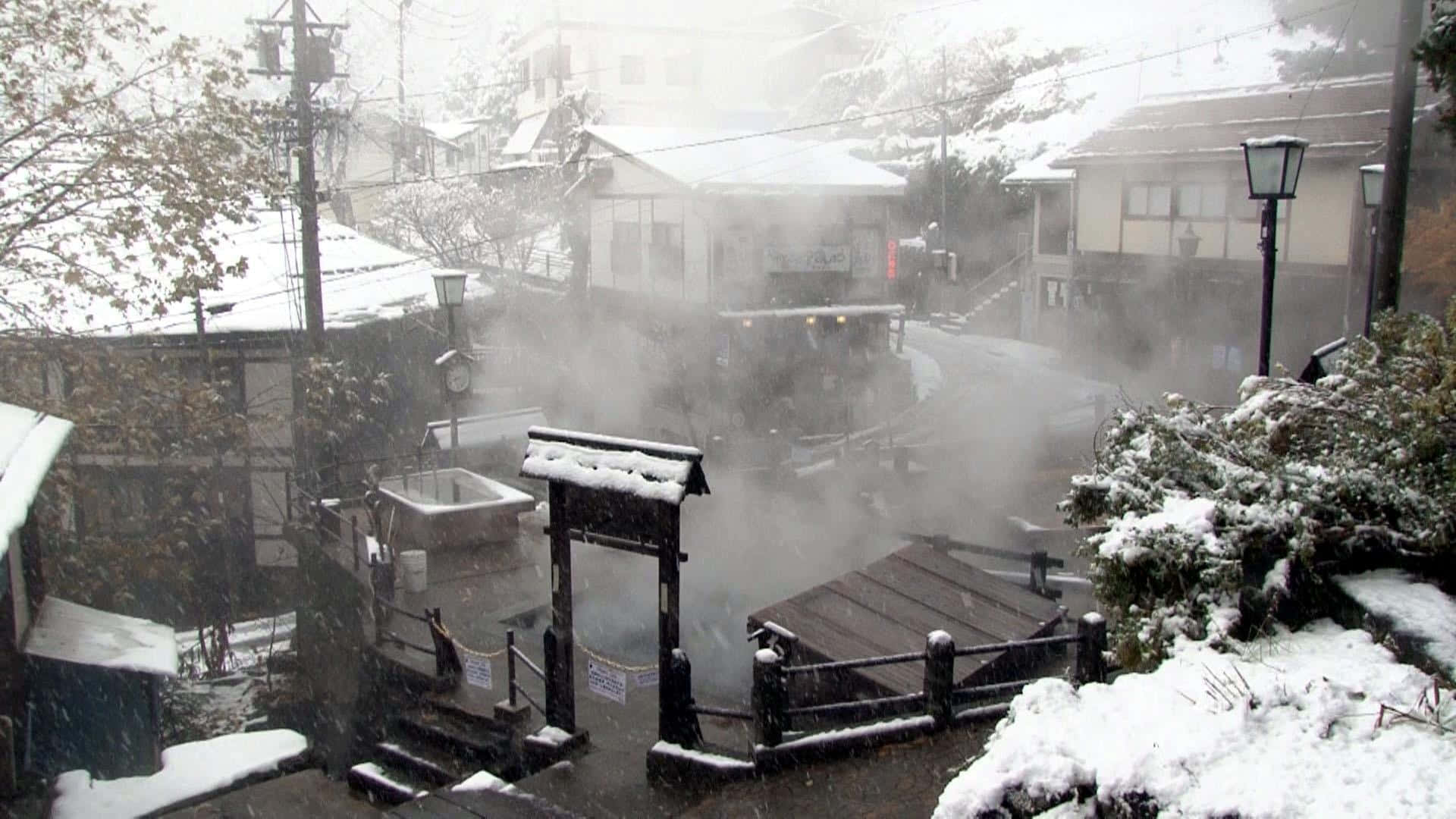 白雪覆蓋的日本溫泉村莊，蒸汽從溫泉浴池中升起。