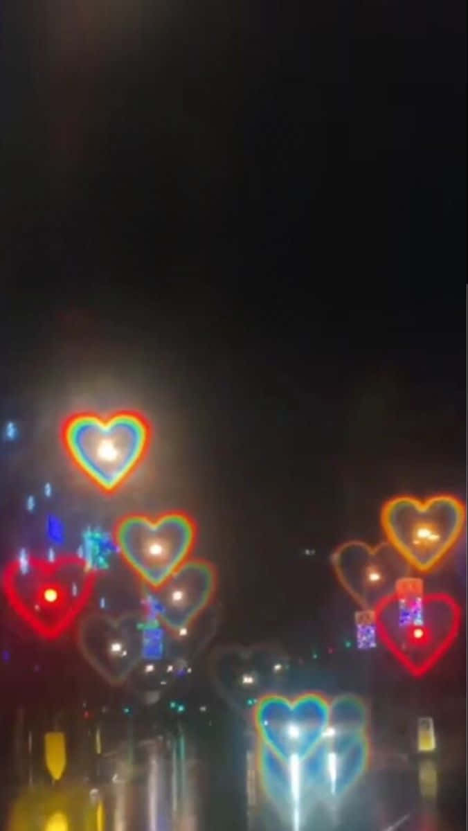 彩色心形燈光在夜晚濕漉漉的城市街道上閃爍。 — 粉紅色心形動圖 壁紙