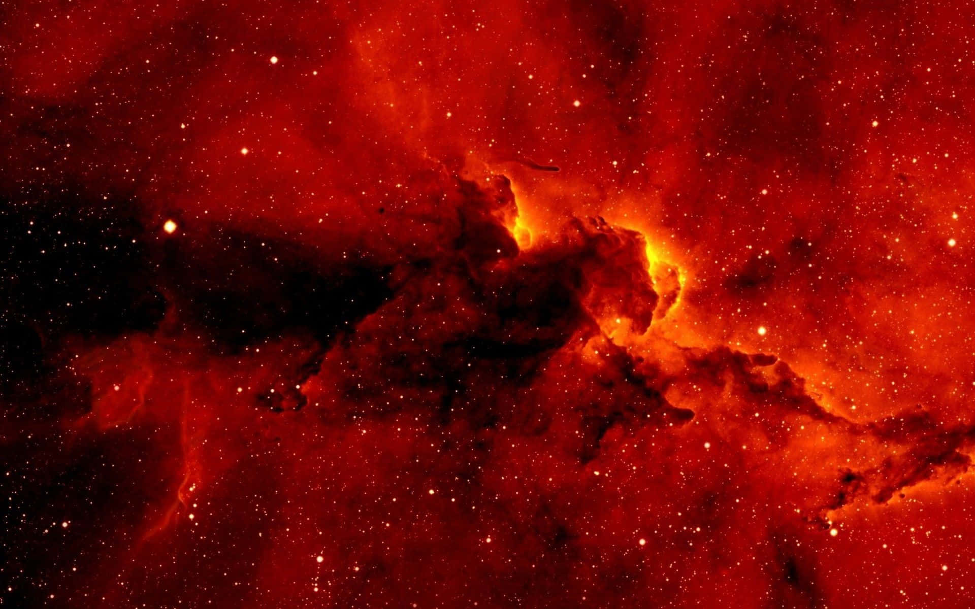 以鮮豔紅色美學打造完美電腦佈置 壁紙 — 一片火紅的星雲，帶有發光的橙色核心和散落的星星，充滿了宇宙的虛空。