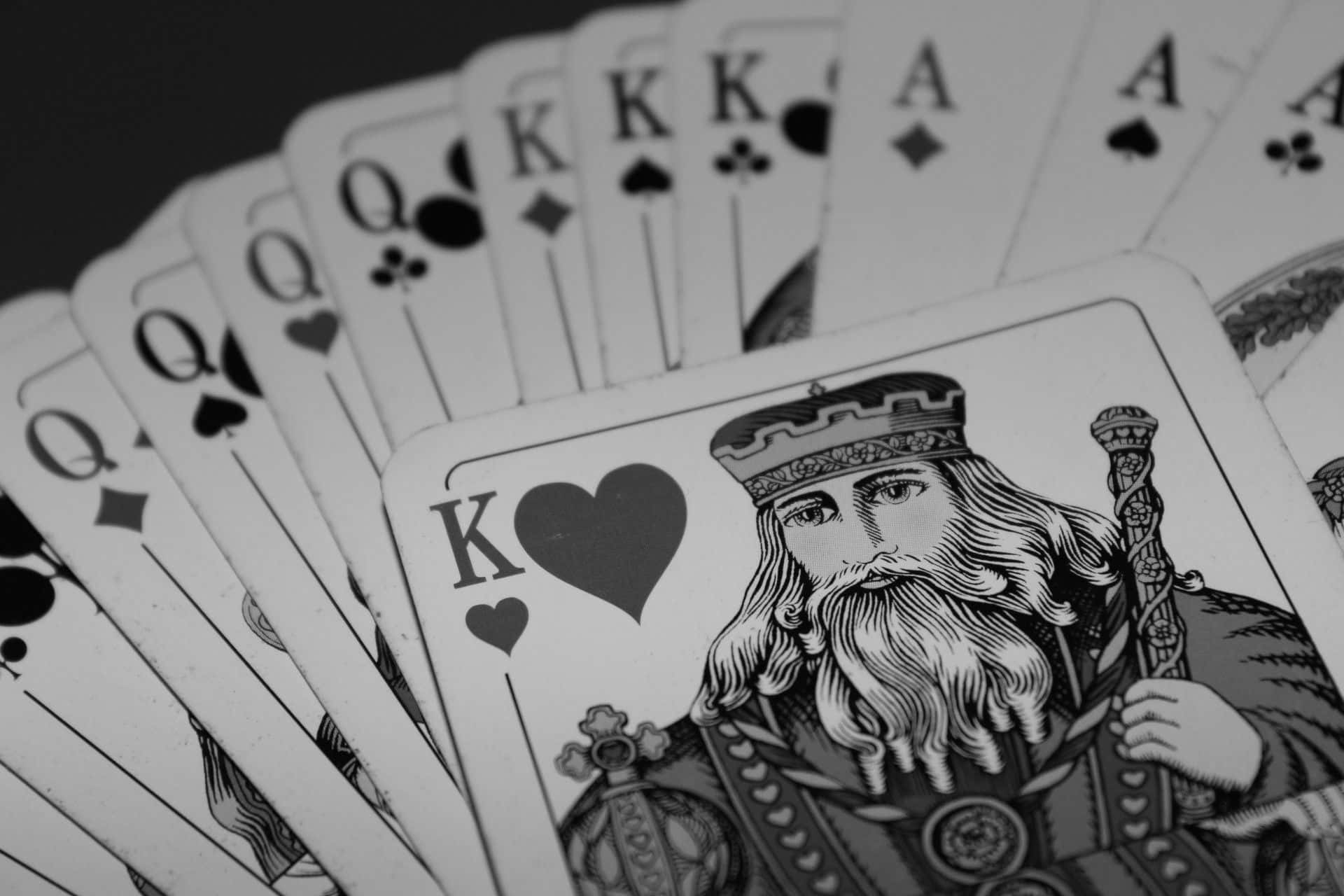 Card Games 桌布 壁紙 — 以黑白呈現的扇形撲克牌，紅心K突出顯示。