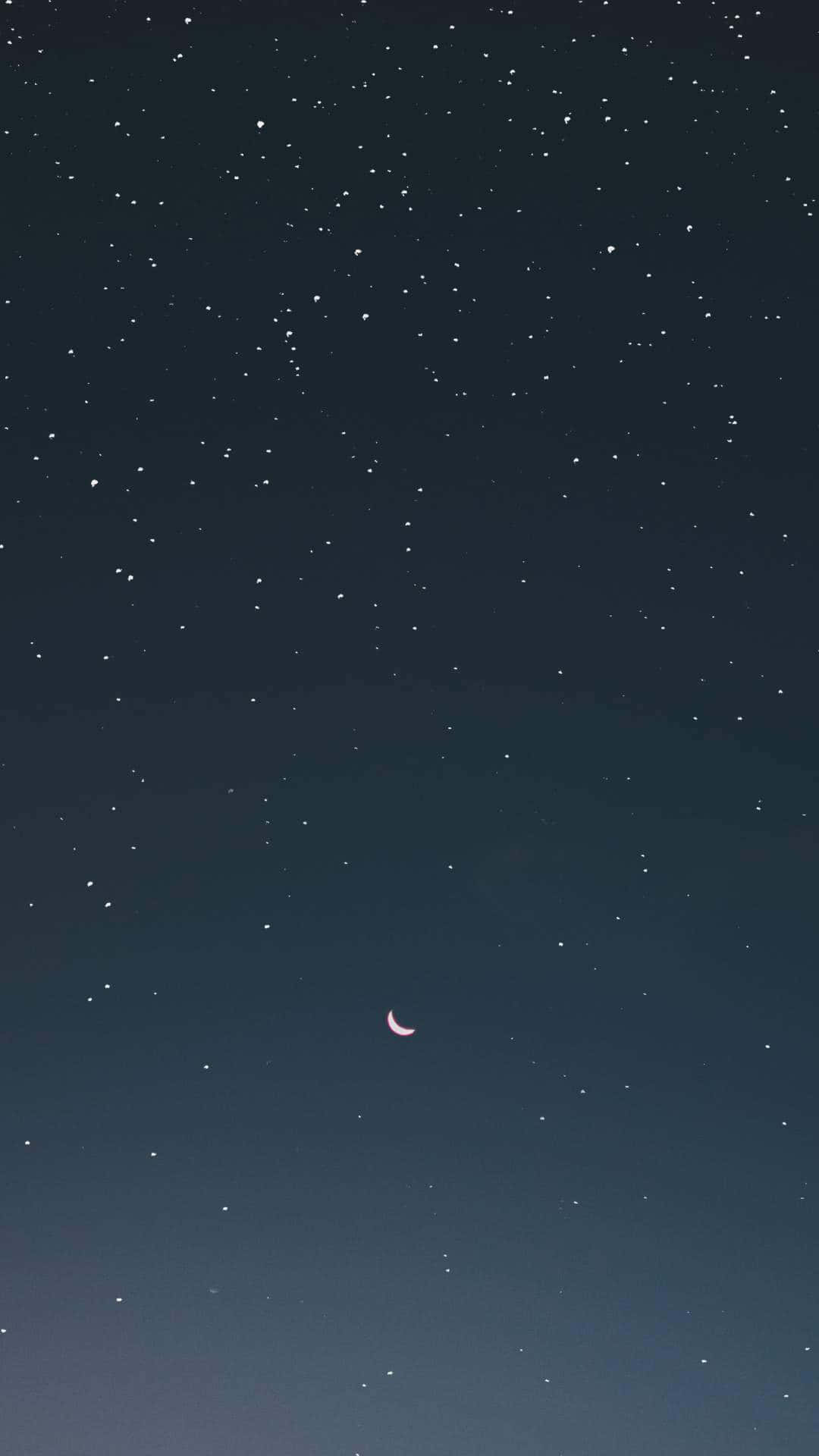 在漆黑的夜空中，一輪粉紅色新月在無數星星中閃耀。