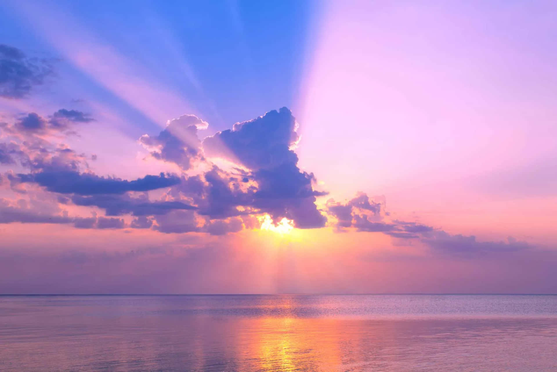 海上的日落，耀眼的光芒和紫色雲彩映照在平靜的水面上。