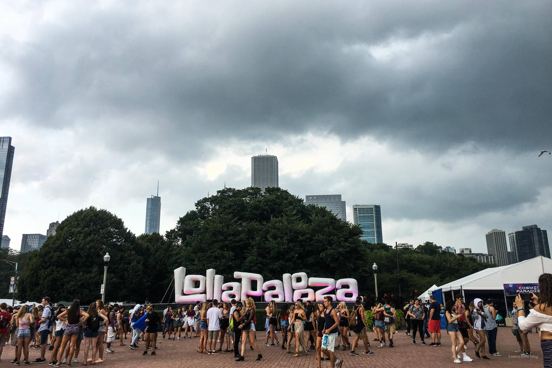 人們在Lollapalooza音樂節上，天空多雲，背後是城市建築。