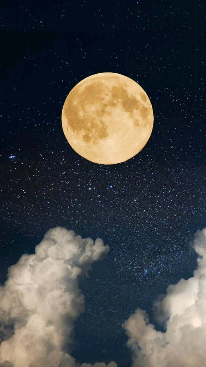 滿月在繁星點點的夜空下，在蓬鬆的雲朵上方明亮地照耀。