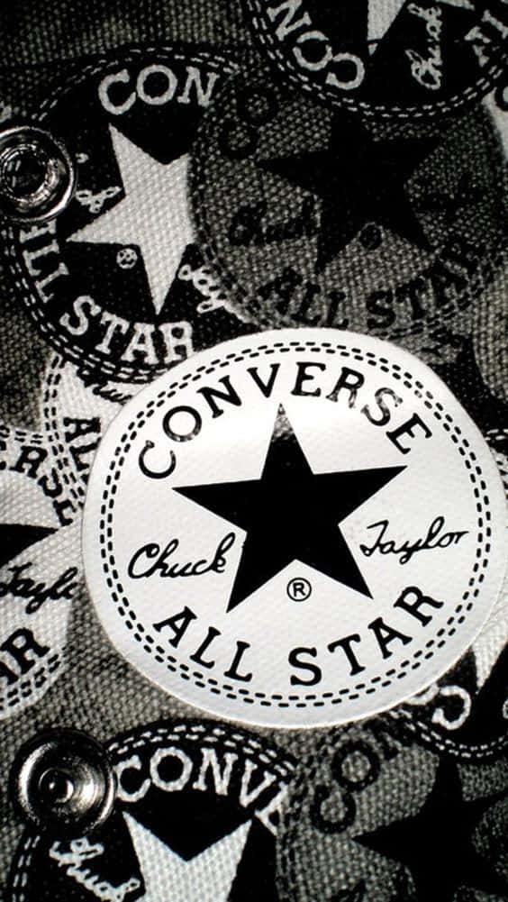 任何場合都適合的經典鞋款 壁紙 — 特寫一個帶有重複Converse All Star標誌和金屬孔眼的紋理布料。