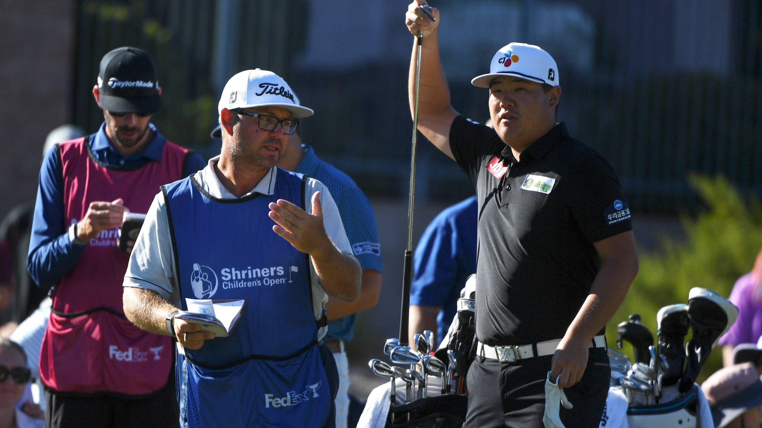 任成宰與球僮 壁紙 — 高爾夫球手在 Shriners Children's Open 賽事中高舉球桿慶祝，球童做出手勢。